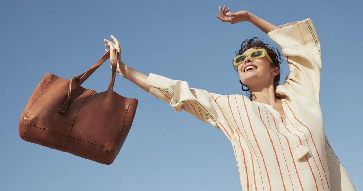 A woman holding a handbag in the sunlight