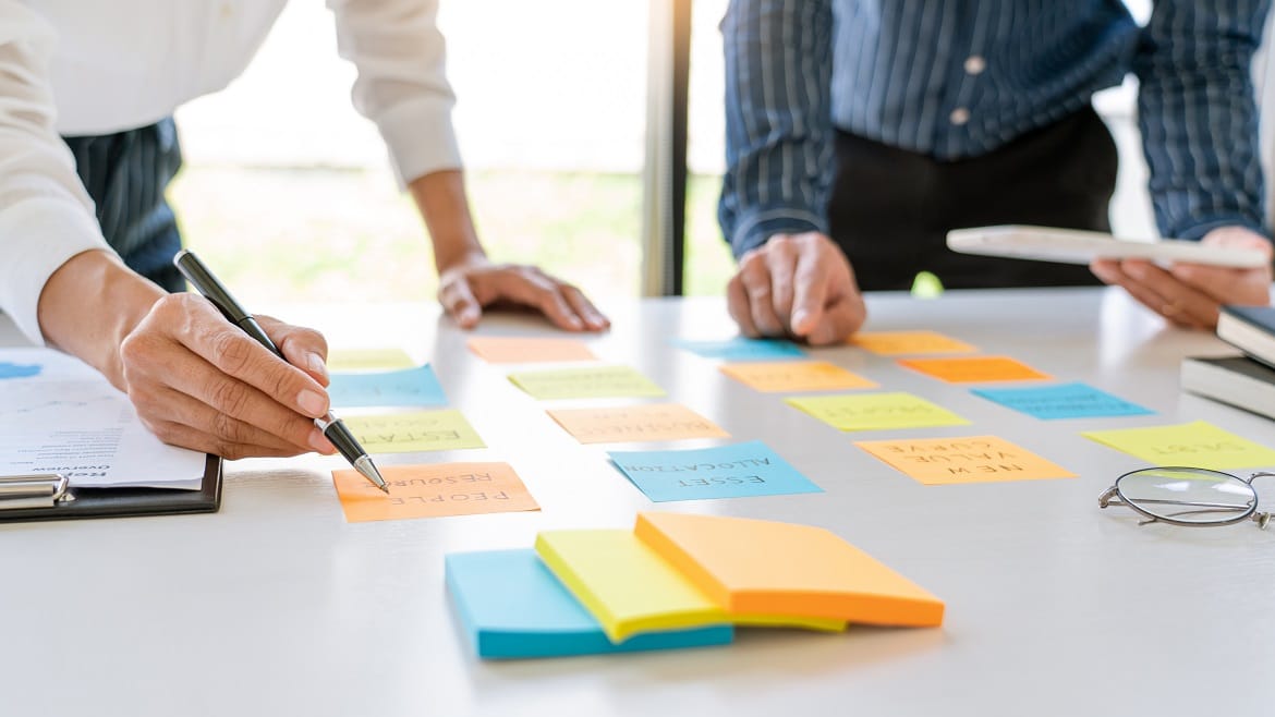 Young,Business,Workers,Posting,With,Sticky,Notes,Stickers,Reminders,Creative