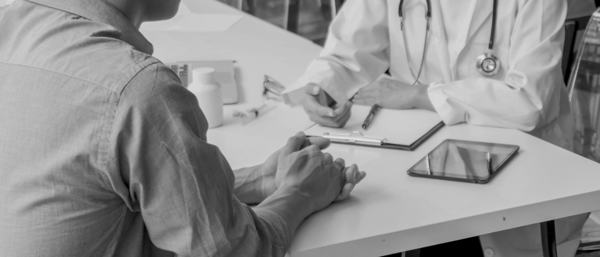 A doctor consults with a patient, supported by digital technology